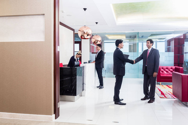 Manager welcoming business associate in office lounge - Photo, Image
