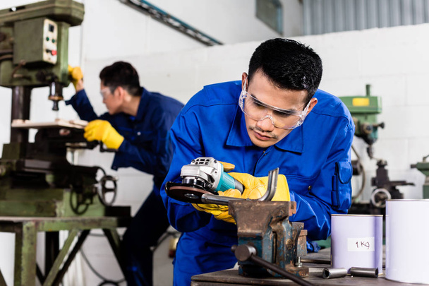Metal workers in industrial workshop grinding - Photo, Image