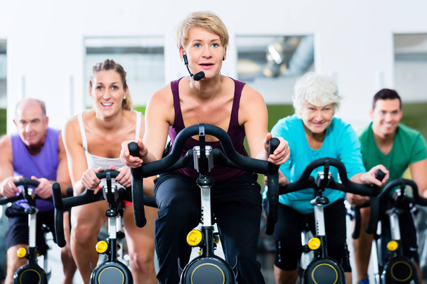 Personas mayores en el gimnasio girando en bicicleta de fitness
 - Foto, Imagen