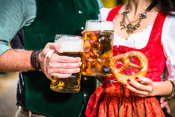 Руки с пивом и крендельками, детали баварской трахты
  - Фото, изображение