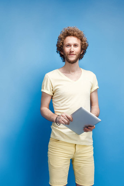 Young curly-haired man with tablet - Foto, Bild