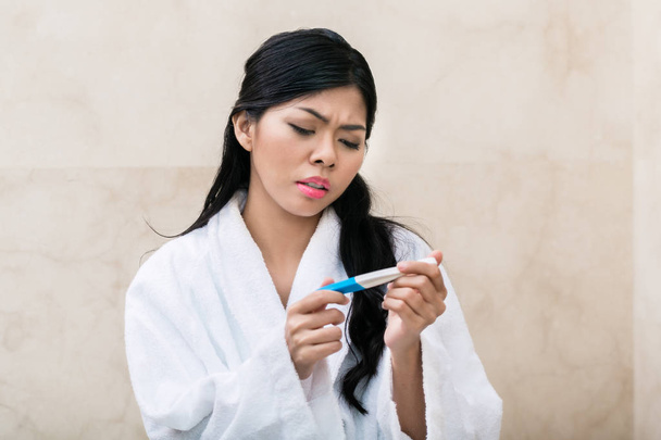 Ασιατικές γυναίκα είναι λυπημένος με τεστ εγκυμοσύνης - Φωτογραφία, εικόνα