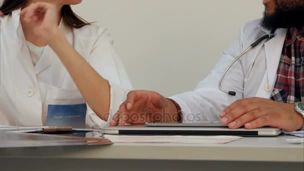 Female and male doctor hands at the desk with laptop and papers - Filmati, video