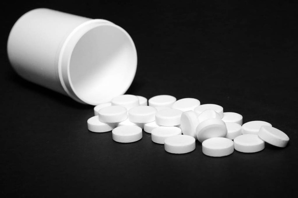 Pílulas brancas, medicamentos, em um fundo blach
 - Foto, Imagem