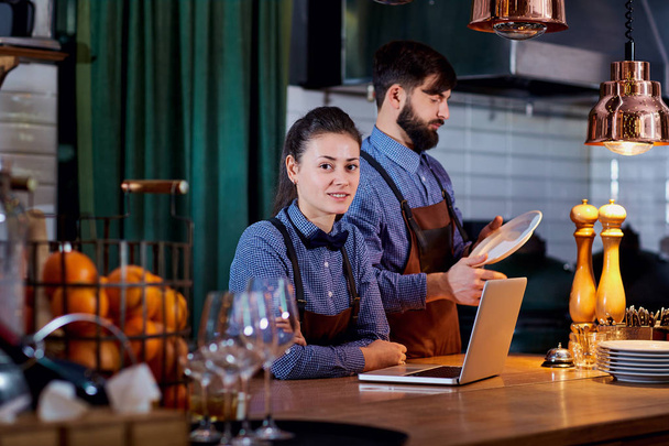 The bartender barista with a laptop at work in restaurant bar ca - Foto, Bild
