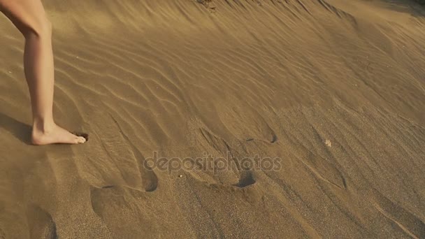 Une femme s'enfuit sur une dune. Empreintes de pas sur Sand. Coucher de soleil sur le désert. Mouvement lent
. - Séquence, vidéo