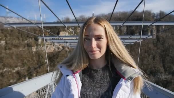 Kobieta przejść do przodu most nad kanionem przed kamerą - Materiał filmowy, wideo