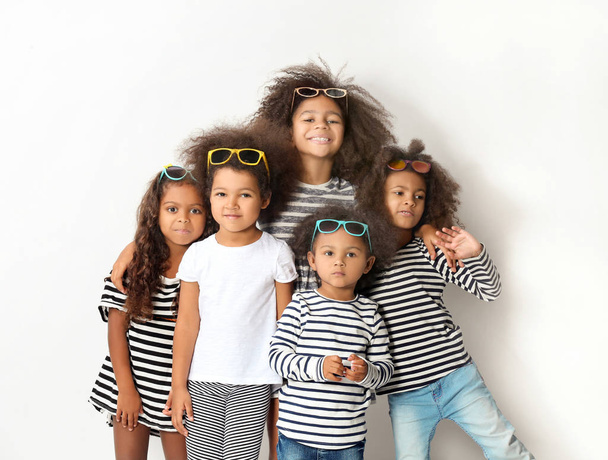 Five cute African girls in striped clothes on white background - Photo, Image