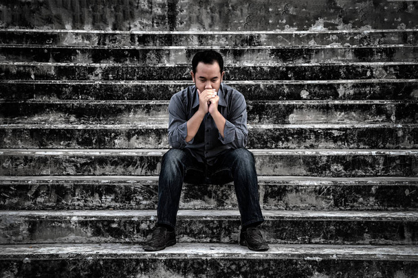 Geschäftsmann in frustrierter Depression sitzt auf der Treppe, in beängstigend verlassenem Gebäude. - Foto, Bild