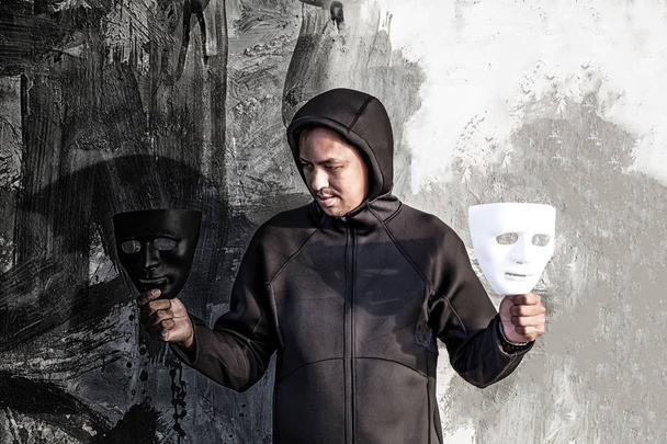 hombre elige entre máscara en blanco y negro
 - Foto, imagen