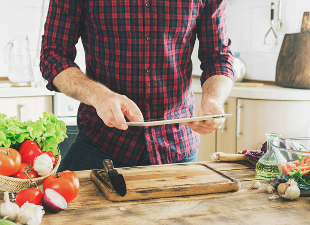 Man following recipe healthy food in kitchen at home - Zdjęcie, obraz