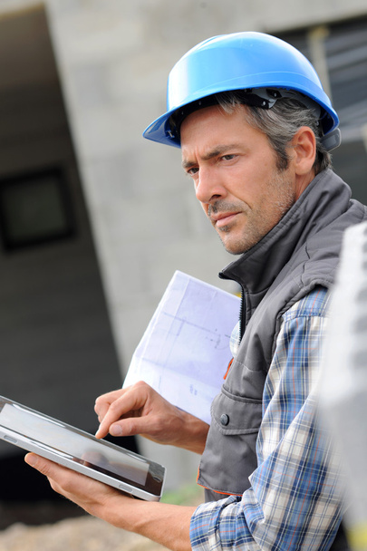 Entrepreneur on construction site using electronic tablet - 写真・画像
