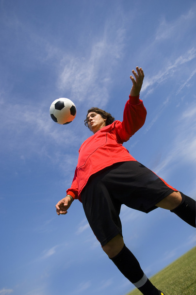 Soccer Football Player in red controlling ball - Fotó, kép