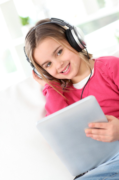Little girl with headphones and electronic tablet - Fotoğraf, Görsel