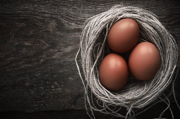 Easter eggs in a nest on a wooden background - Photo, Image