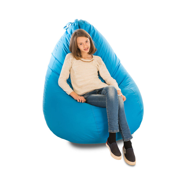 Young cute girl sitting on blue beanbag  - Photo, image