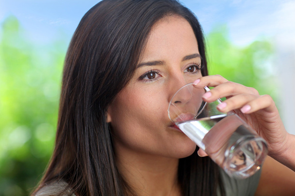 Portrait of smiling woman drinking water - Фото, изображение