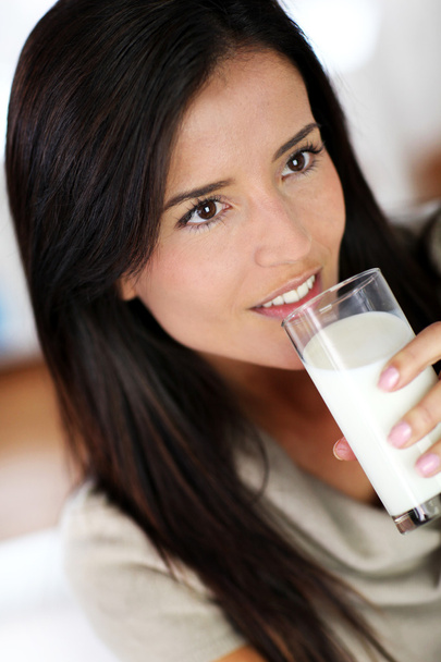 Attractive young woman drinking fresh milk - Фото, зображення
