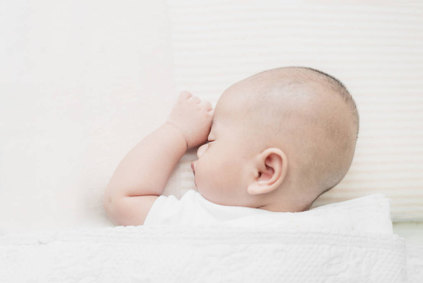 Asiática poco bebé niño durmiendo en suave blanco manta en b
 - Foto, Imagen