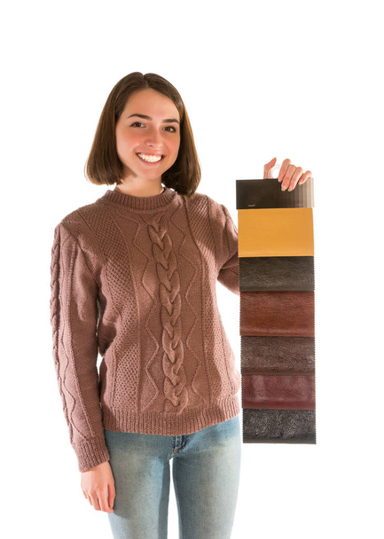 Smiling attractive woman in sweater holding fabric swatches - 写真・画像