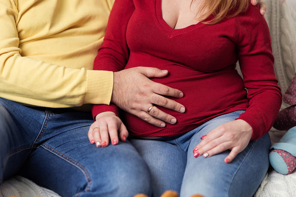 Photo of pregnant woman belly. Hands hugging pregnant belly. Close up of human hands holding pregnant belly. Pregnant woman hugs her belly. Pregnancy. Pregnancy Concept - Foto, Imagen