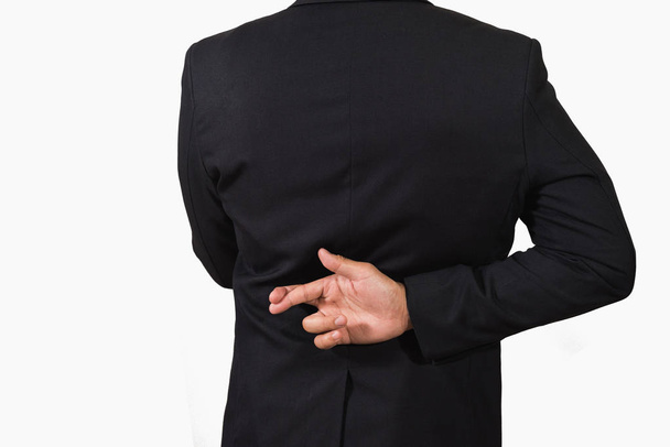 Бизнесмен в темном костюме со скрещенными пальцами за спиной
 - Фото, изображение