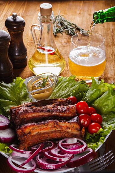 Πλευρών χοιρινού ψημένο με λαχανικά και μουστάρδα και μπύρα έκχυση πέρα δώθε - Φωτογραφία, εικόνα