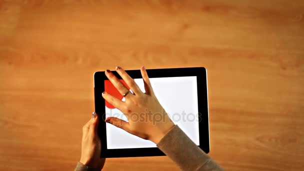 Női piros háttérre támaszkodva tabletta - Felvétel, videó