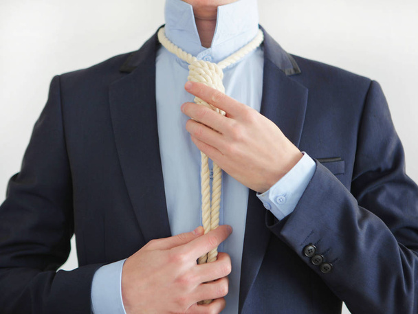 Businessman Adjusting hangman's noose on his neck. - Fotoğraf, Görsel