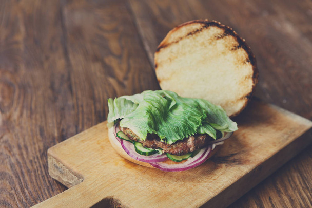 Классический американский бургер, фаст-фуд на деревянном фоне
 - Фото, изображение