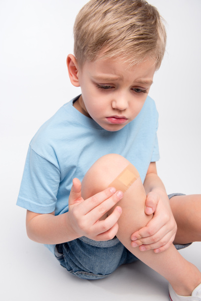 Little boy with patch on knee - Fotó, kép