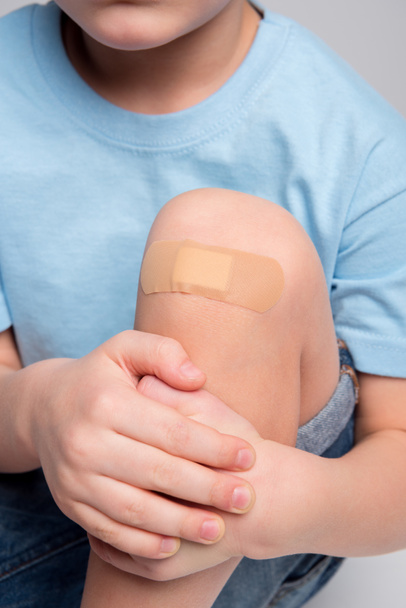Little boy with patch on knee - Φωτογραφία, εικόνα