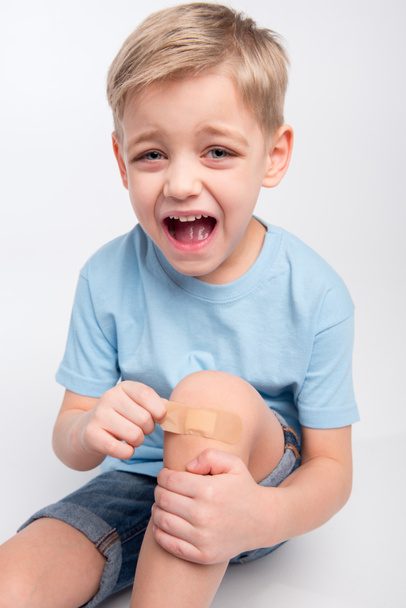 Little boy with patch on knee - Фото, зображення