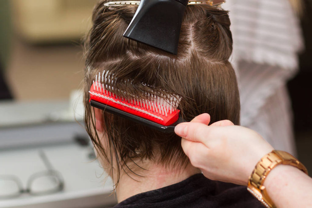 Friseur trocknet dem weiblichen Kunden das nasse Haar - Foto, Bild