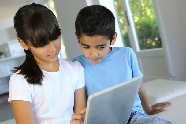 Children playing with electronic tablet at home - Photo, image