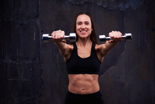 Auto-retenue femme faisant biceps boucle avec haltères
 - Photo, image