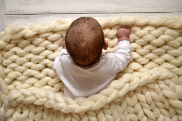 Small child in a blanket of thick yarn. Christmas theme. Happy Valentines Day - Photo, Image