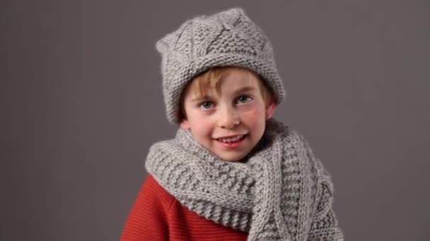 smiling boy with freckles wearing wool winter hat and scarf - Filmati, video