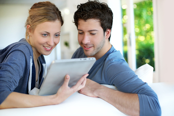 Young couple using electronic tablet - Fotó, kép