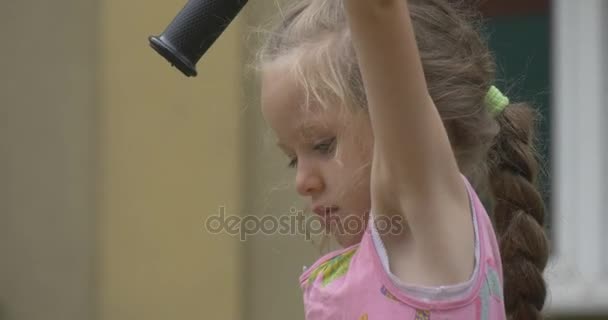 Küçük sarışın kız bir çubukları üzerinde asılı olan - Video, Çekim
