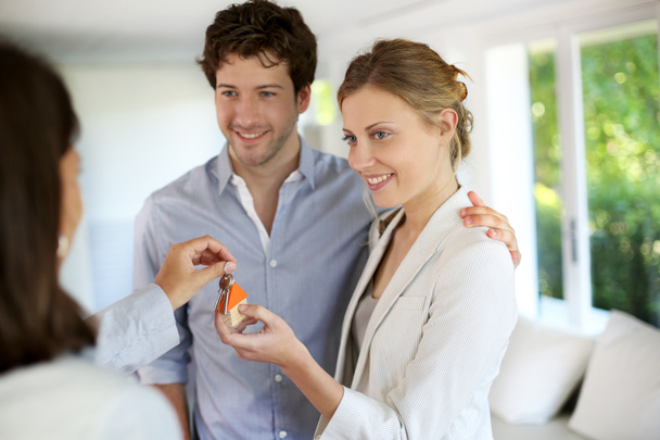 Happy young couple getting keys of their new home - Photo, Image
