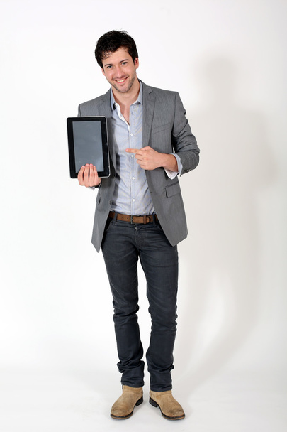 Young cheerful guy holding electronic tablet - Foto, imagen