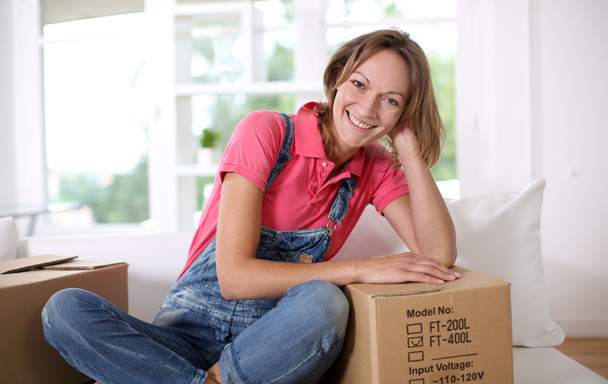 Portrait of cheerful woman moving in new house - Fotoğraf, Görsel