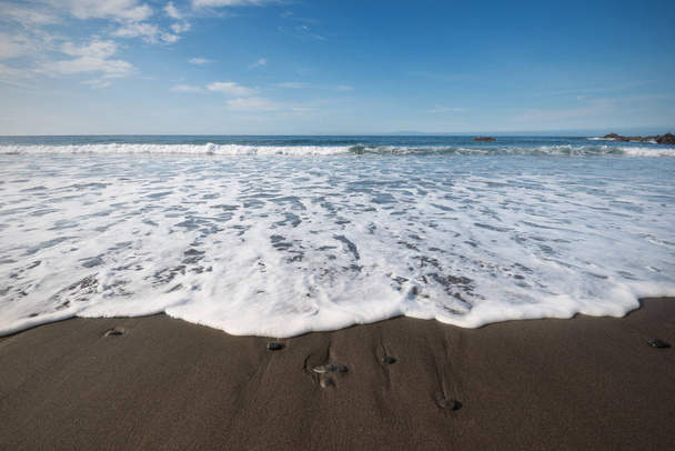 espuma de agua en la playa de arena volcánica en La Gomera, Islas Canarias, España
. - Foto, Imagen