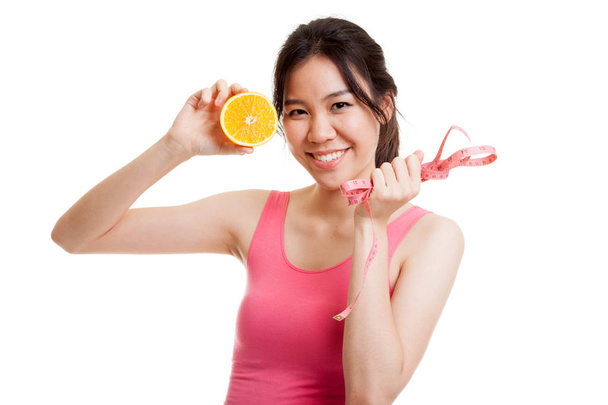 Asian healthy girl on diet with orange fruit and measuring tape. - 写真・画像