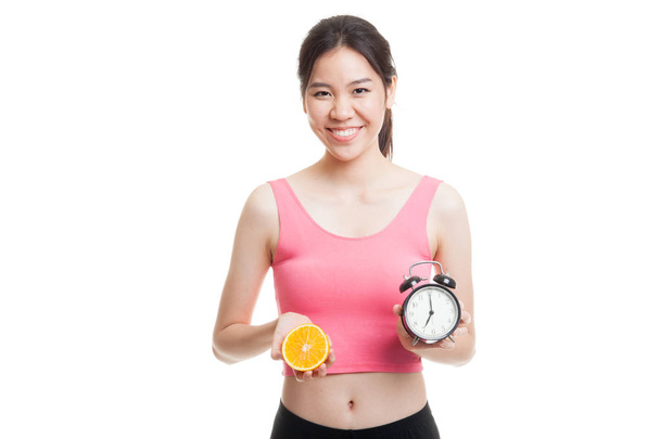 Beautiful Asian healthy girl with orange and clock. - Fotó, kép