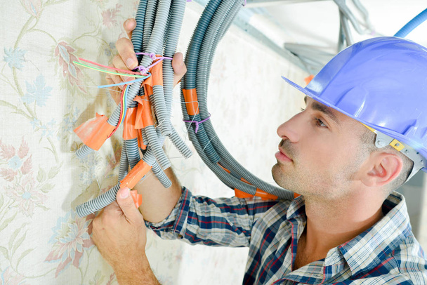 Construtor segurando cabos junto com fita e laços
 - Foto, Imagem