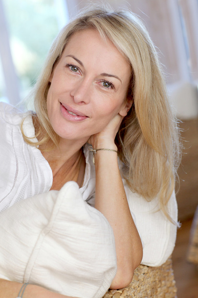 Portrait of blond mature woman relaxing in sofa - Photo, image
