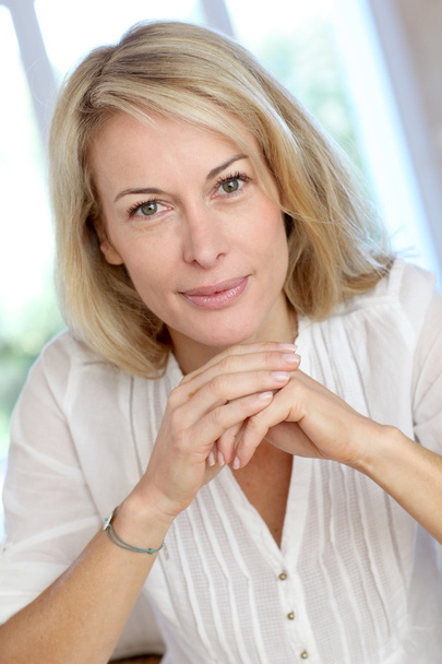 Portrait of blond mature woman relaxing in sofa - Foto, immagini