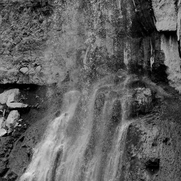 Caída de agua sobre roca texturizada
 - Foto, imagen